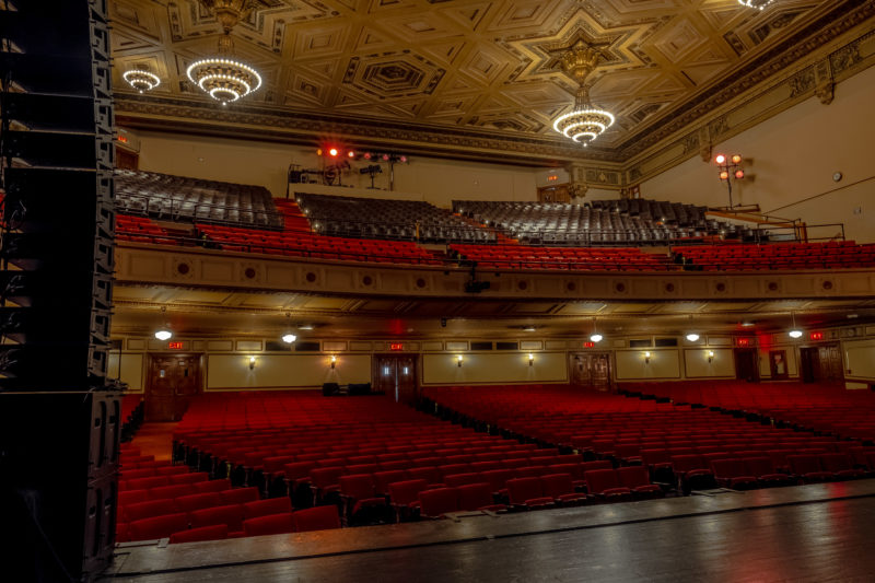 View of the theater seating from stage left, with a stack of Meyer Sound speakers on the side